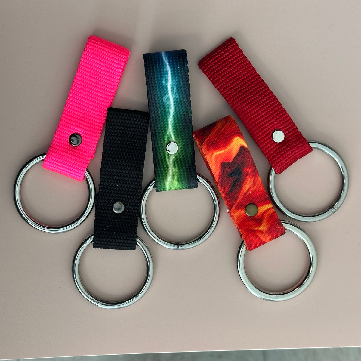Belt-loop bandana holders in pink, black, blue-green lightning, orange flame, and red