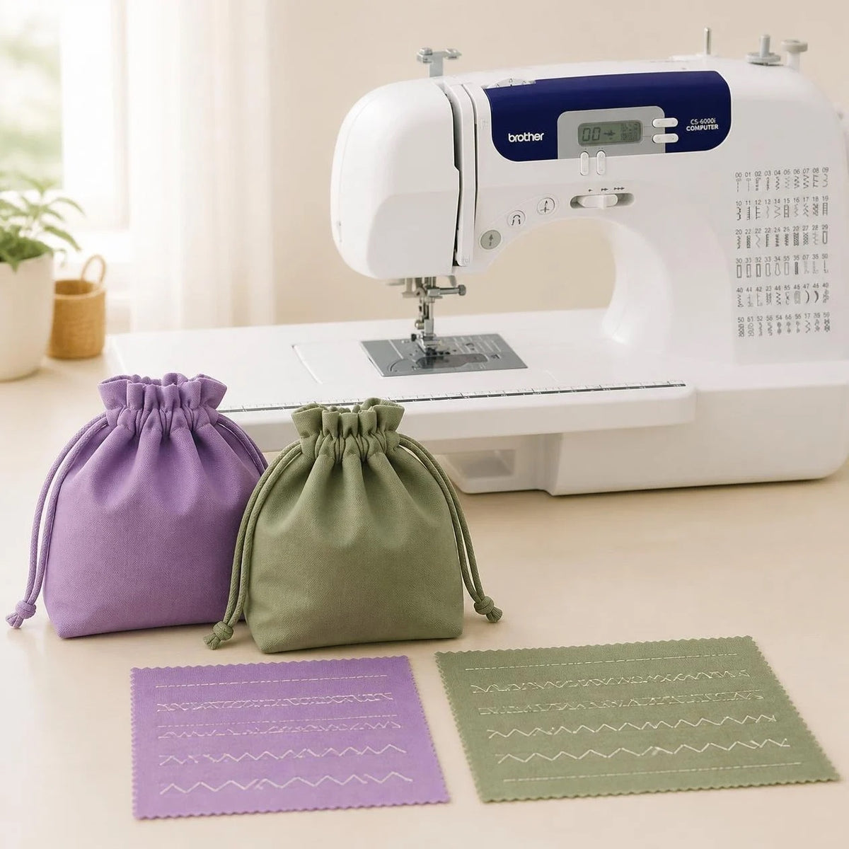 Lavender and sage drawstring bags and practice-stitch samples beside a sewing machine.